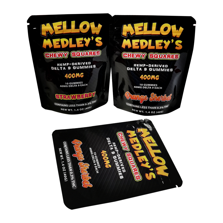 Glossy black printed gummy pouches, including one laid flat, in a coordinated yellow-lettered series