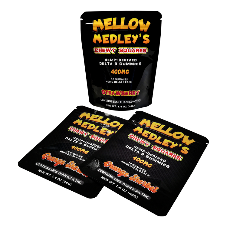 Glossy black gummy pouches with coordinated printed designs across a product series