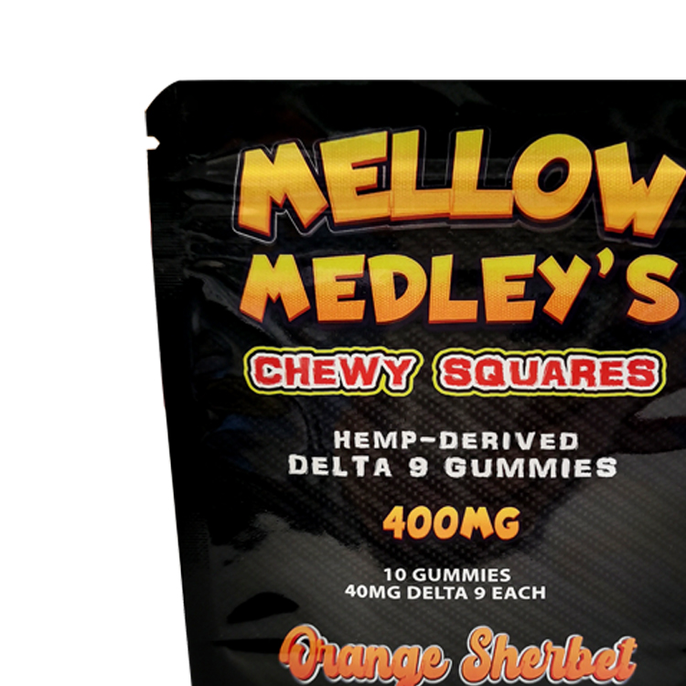 Close view of a glossy black gummy pouch with colorful printed artwork