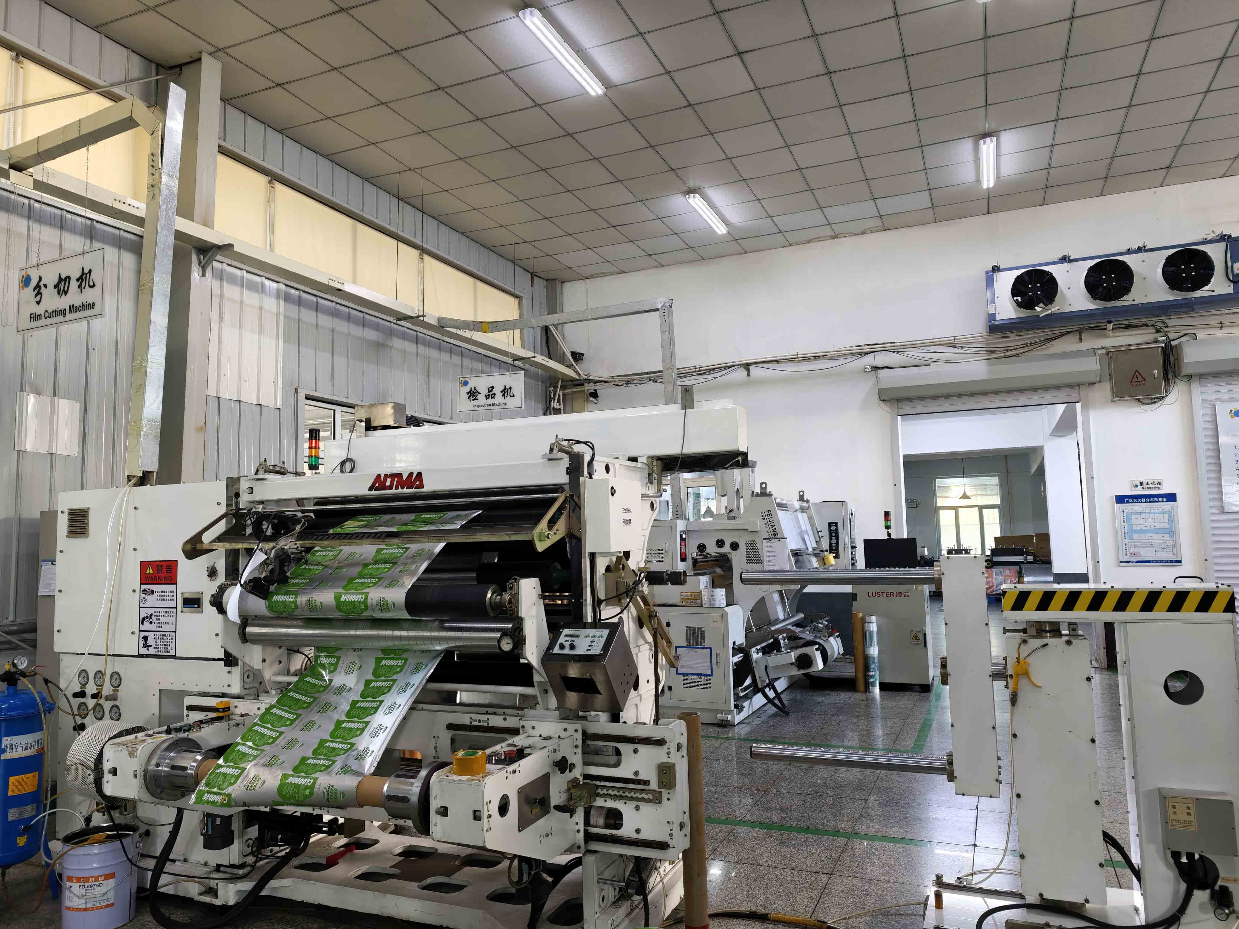 Film slitting equipment processing printed material in the packaging workshop