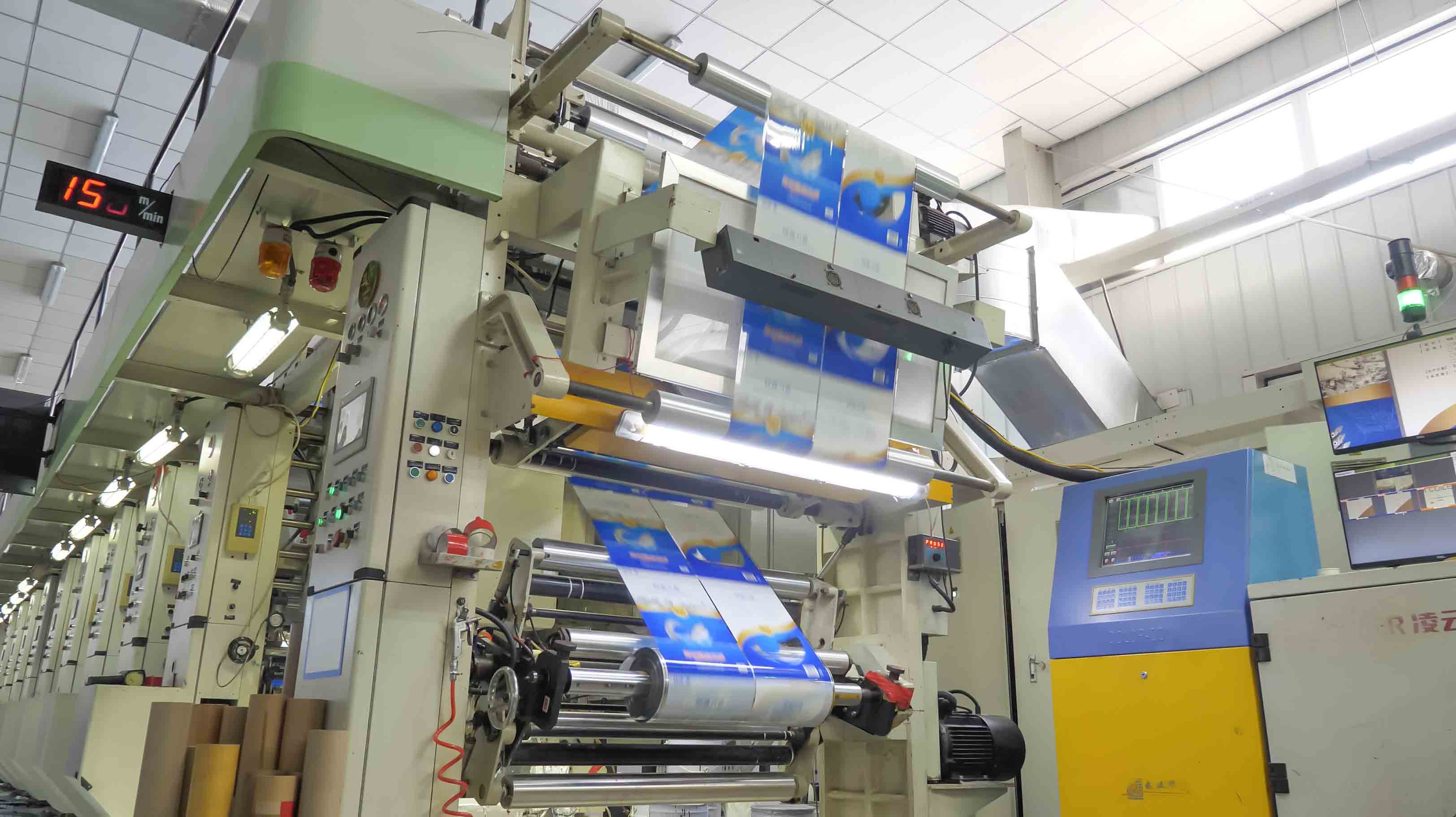 Pouch-making machinery processing a roll of printed blue packaging film