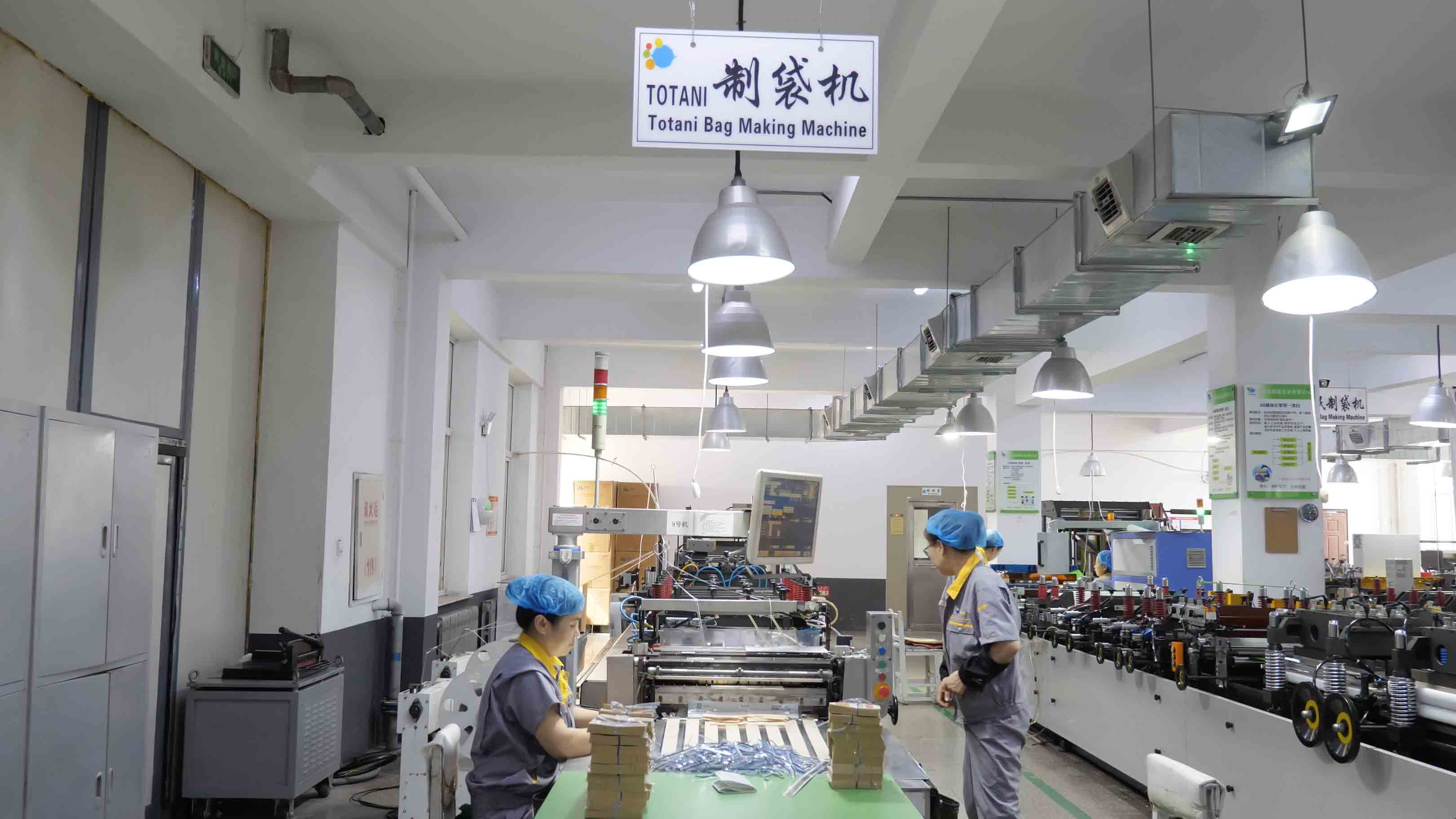 Operators working beside a flexible packaging production line