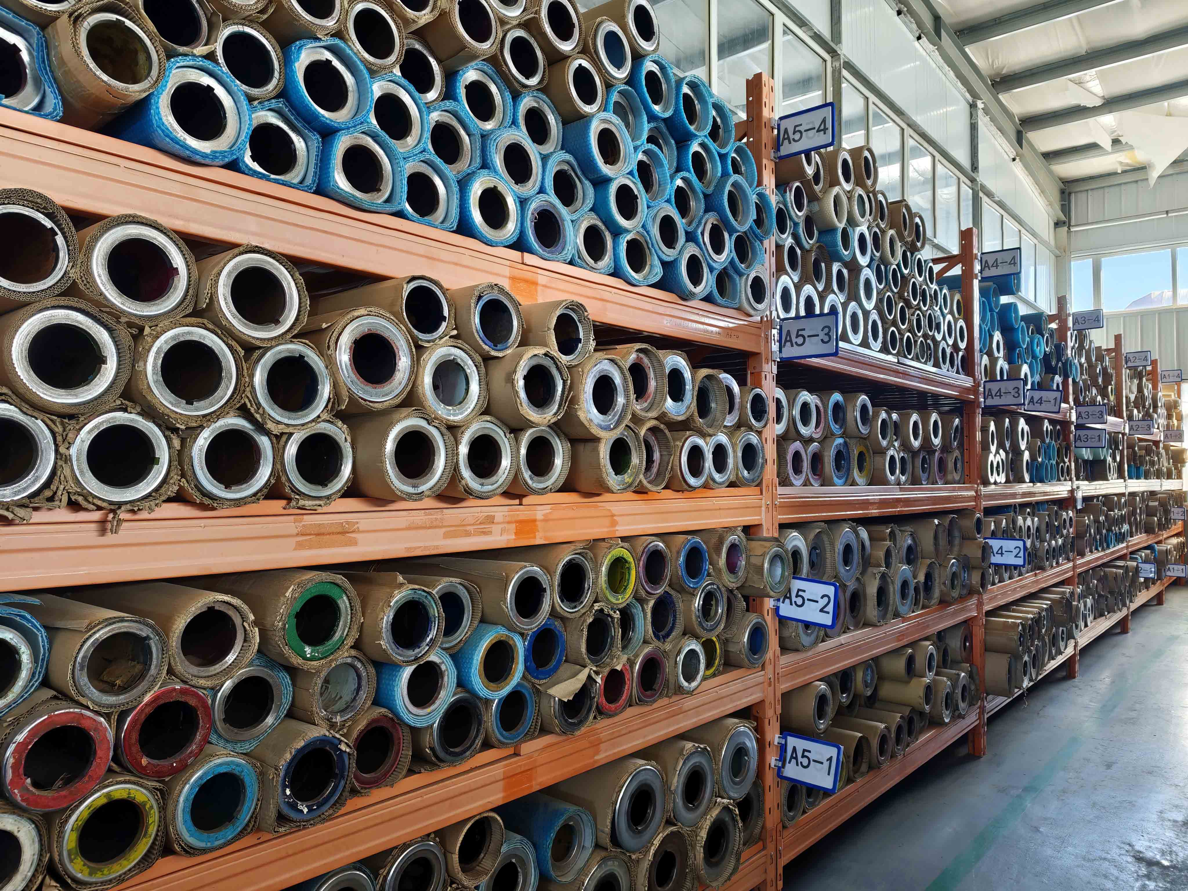 Rows of gravure printing cylinders stored on racks in the packaging factory