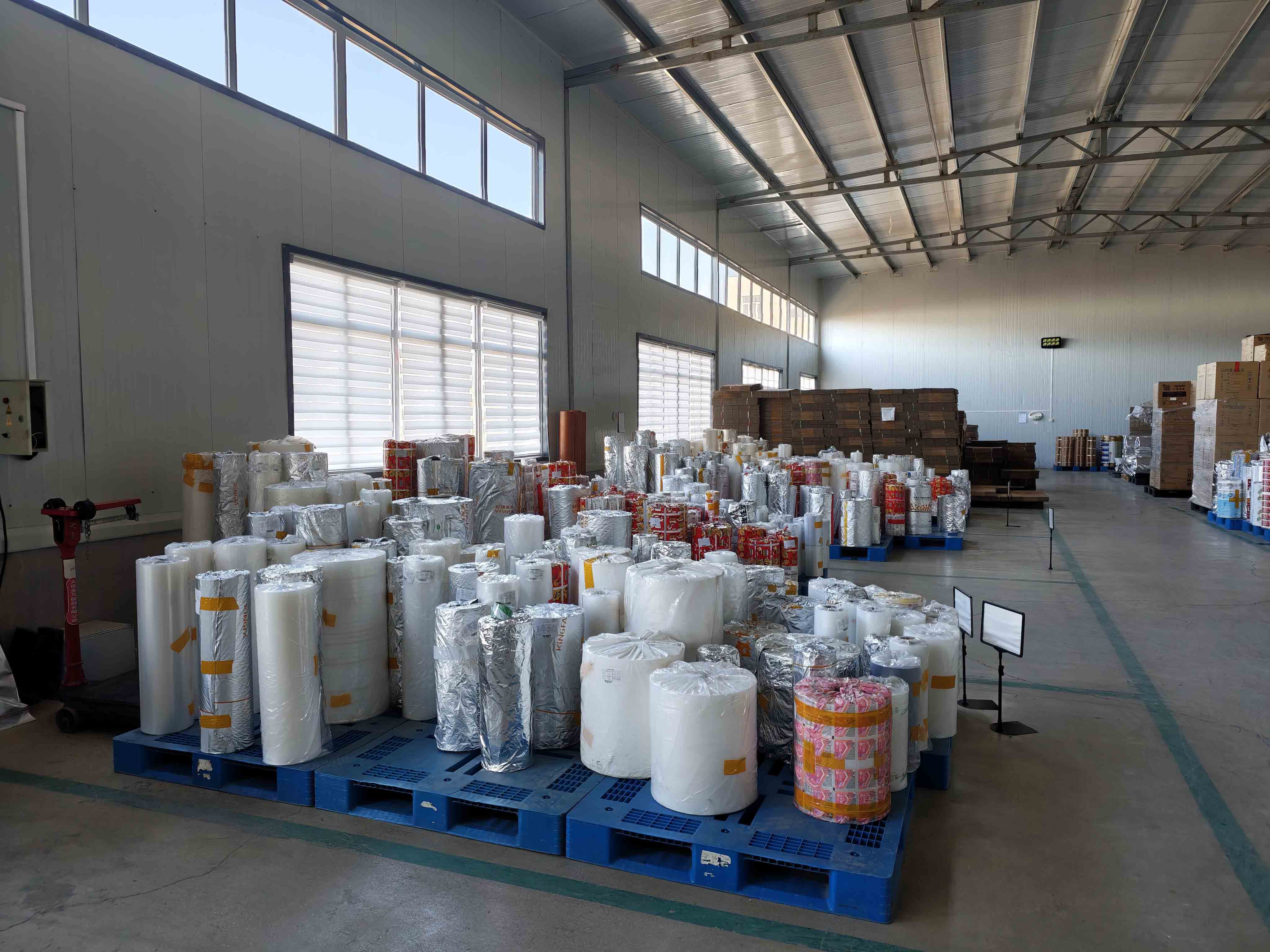 Material film rolls stored on pallets in the factory warehouse